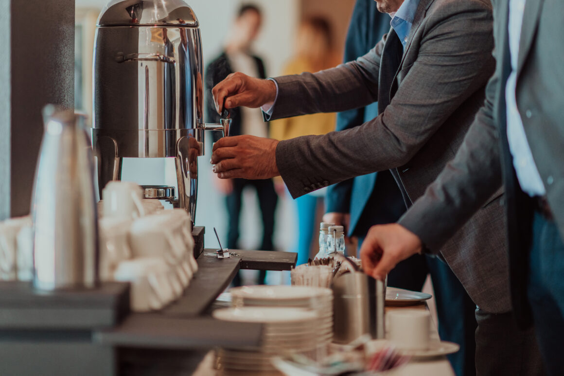Close-up photo of businessmen serving themselves in a modern hotel during a dinner party. Selective focus Eventos Corporativos